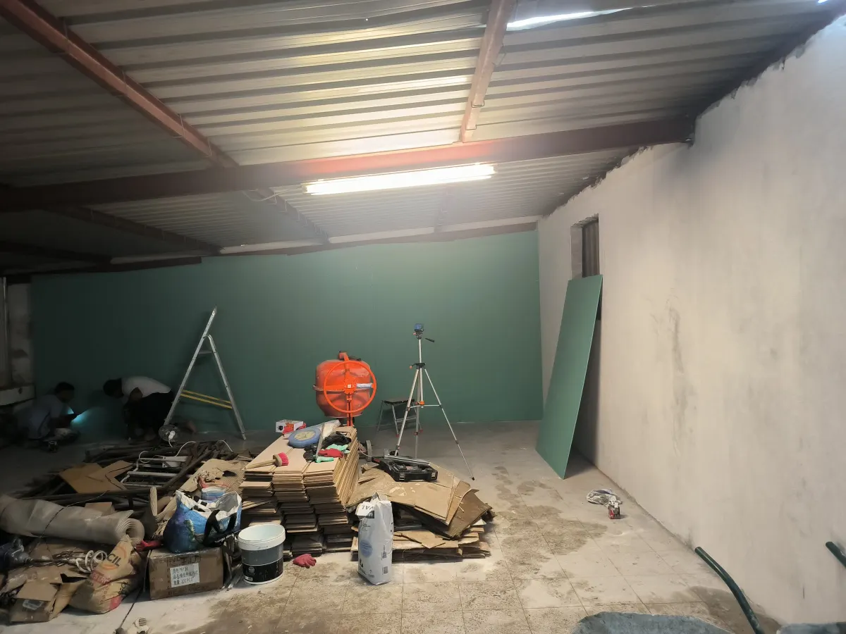Green plasterboard fitted at the far end of the warehouse