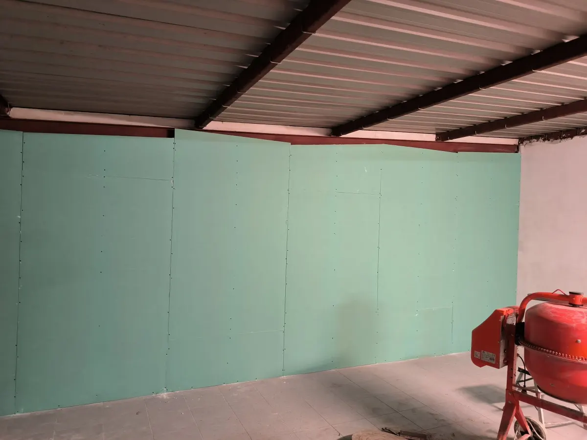 Green plasterboard wall under the metal roof