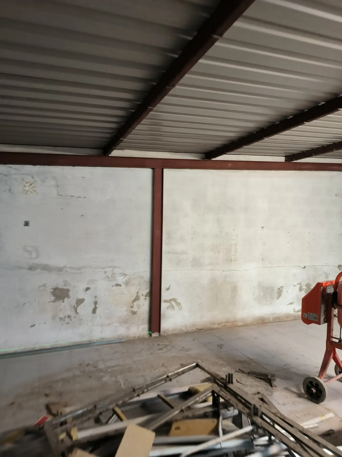 Warehouse before the works, with damaged walls and a metal roof