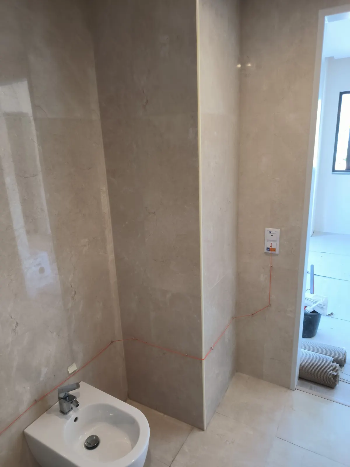 Zona do bidé com revestimento em mármore creme