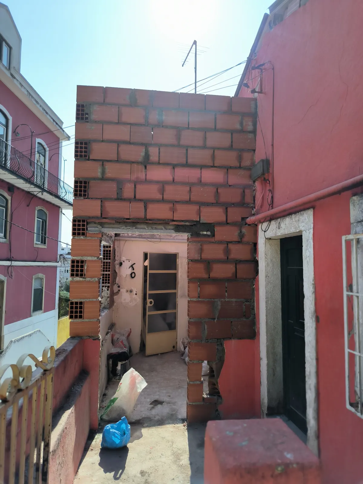 Obra em curso: paredes em tijolo a subir no pátio da moradia
